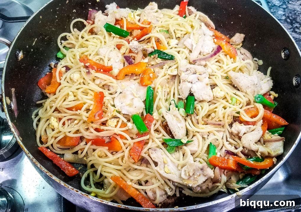 Stir fry with spaghetti and chicken in a pan