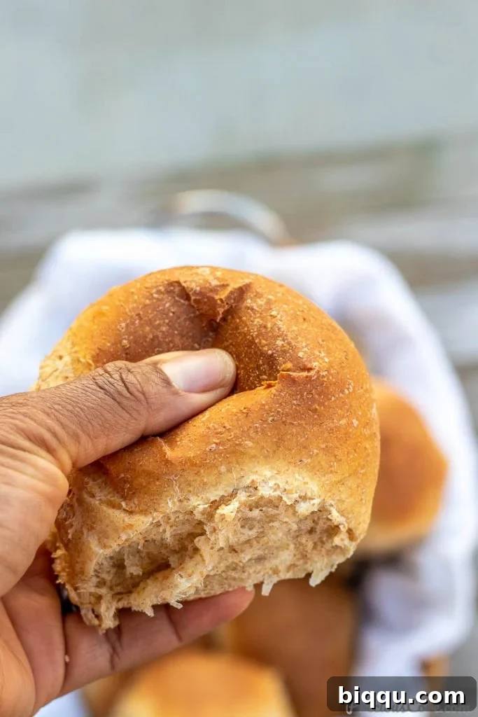 Hand pressing on a soft dinner roll.