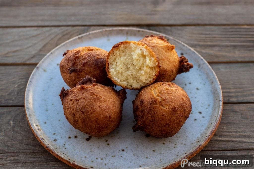 Fluffy Coconut Doughnuts 4 Several golden coconut doughnuts arranged artfully on a plate