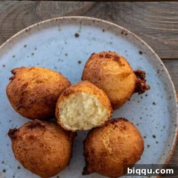 Fluffy Coconut Doughnuts 6 Coconut doughnuts on a plate with one opened up