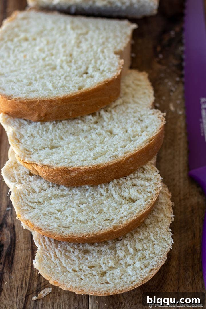 Perfect Everyday Sandwich Bread 2 Slices of homemade sandwich white bread on a chopping board.