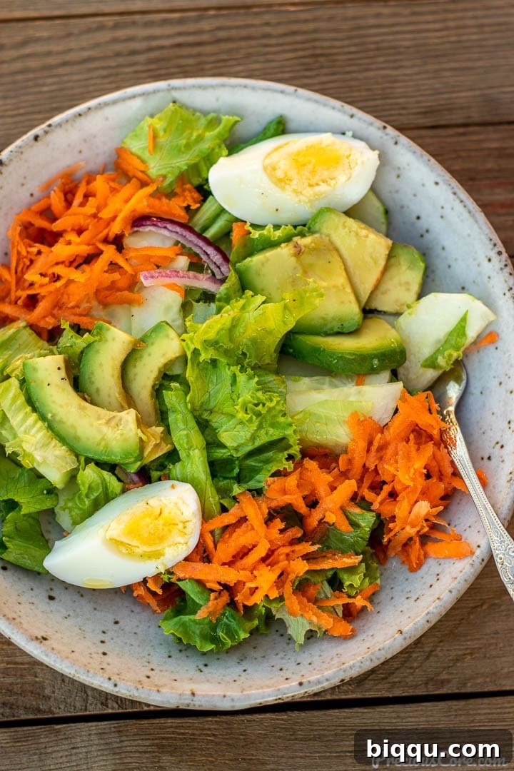 A vibrant serving of lettuce salad in a bowl, glistening with a drizzle of fresh lemon dressing.