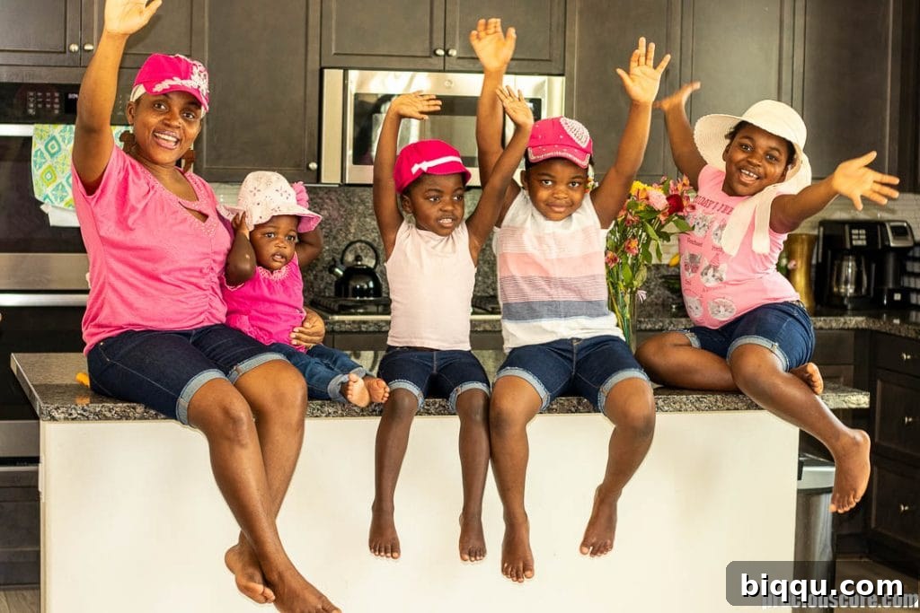 Loving Your Children Deeply 3 A mother and her four daughters happily cooking together in a bright kitchen, sharing a moment of joy and connection.