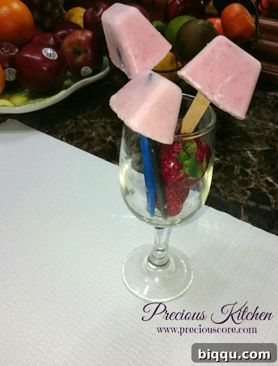 Two strawberry yogurt popsicles on a white plate