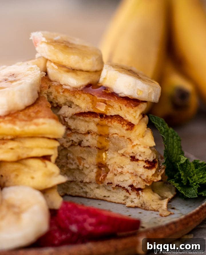 Close-up of sliced banana pancakes with maple syrup dripping down