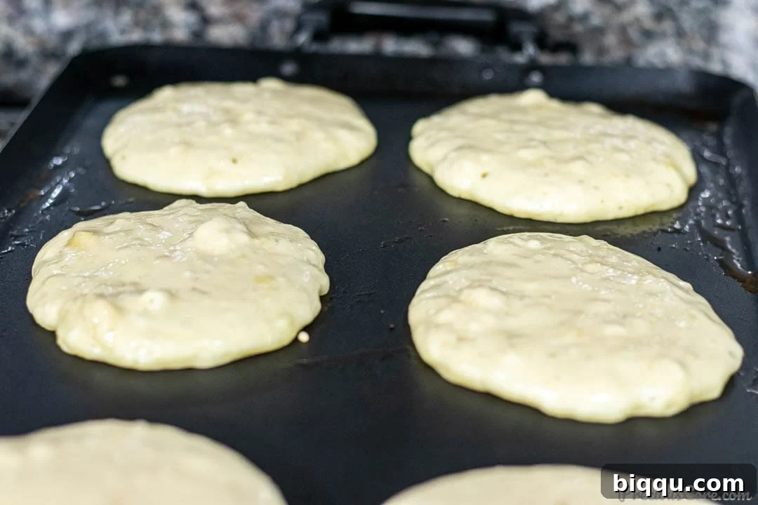 Banana Pancake Batter Cooking on Griddle, showing bubbles forming