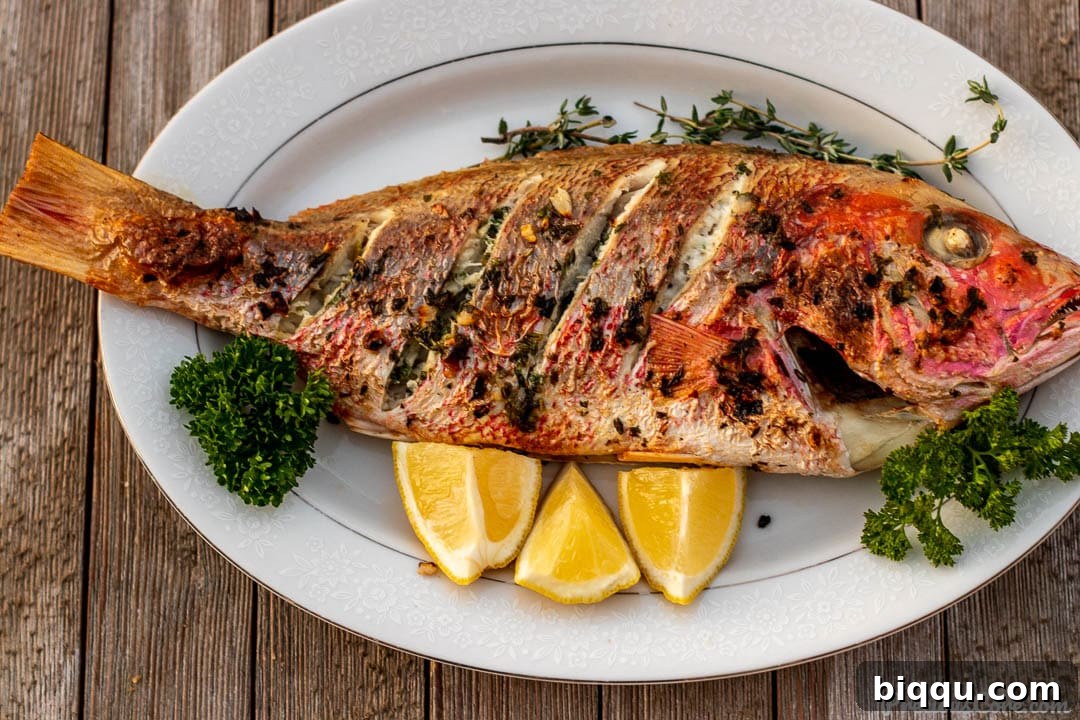 Golden Oven Grilled Whole Red Snapper 9 Beautifully garnished oven-grilled whole red snapper presented on a large platter