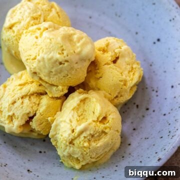 Scoops of mango ice cream in a bowl.