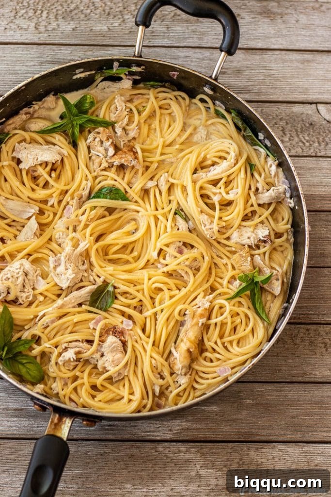 creamy spaghetti in a pan, just tossed with sauce