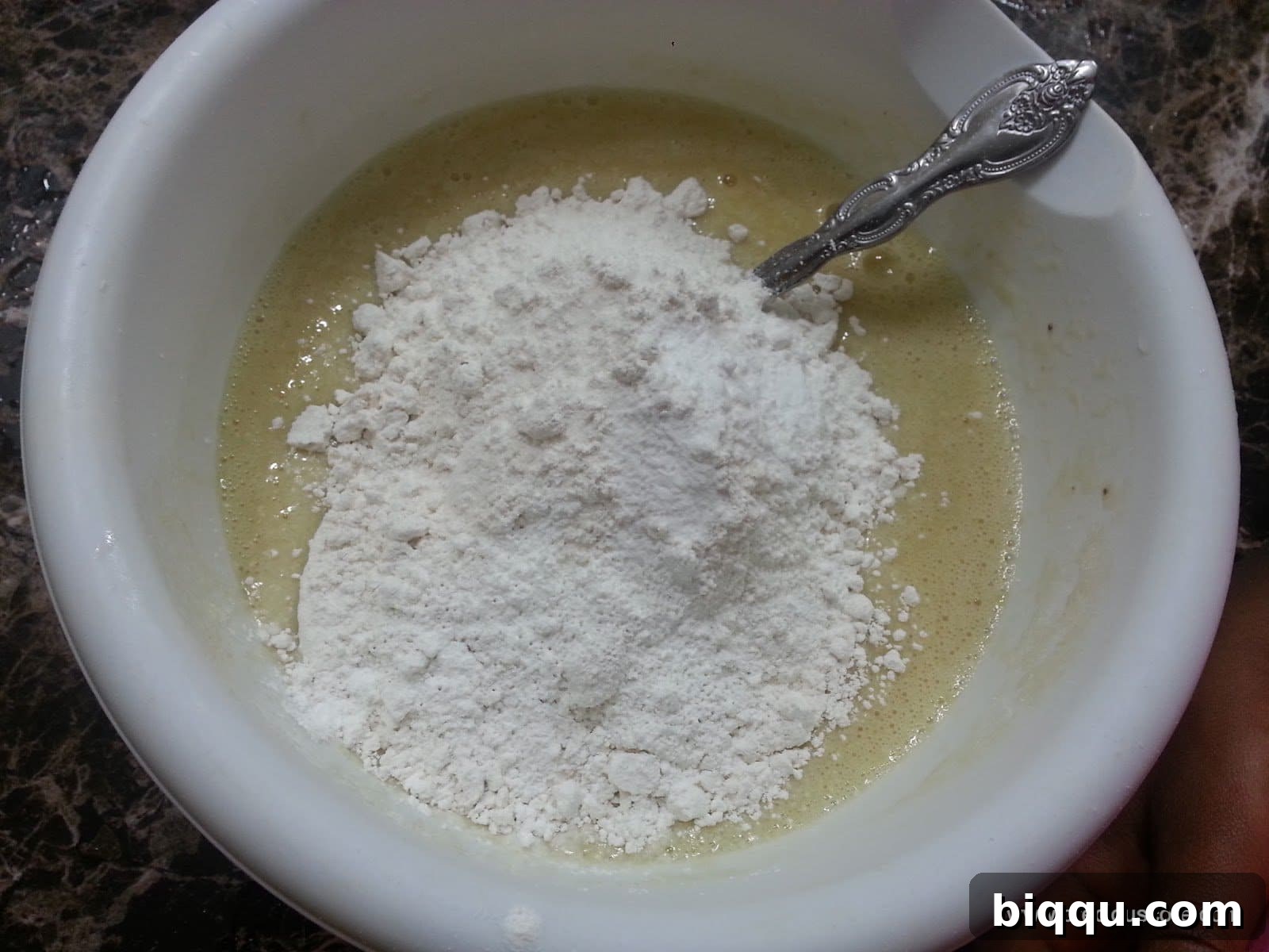 Pile of dry ingredients in a bowl of wet ingredients.