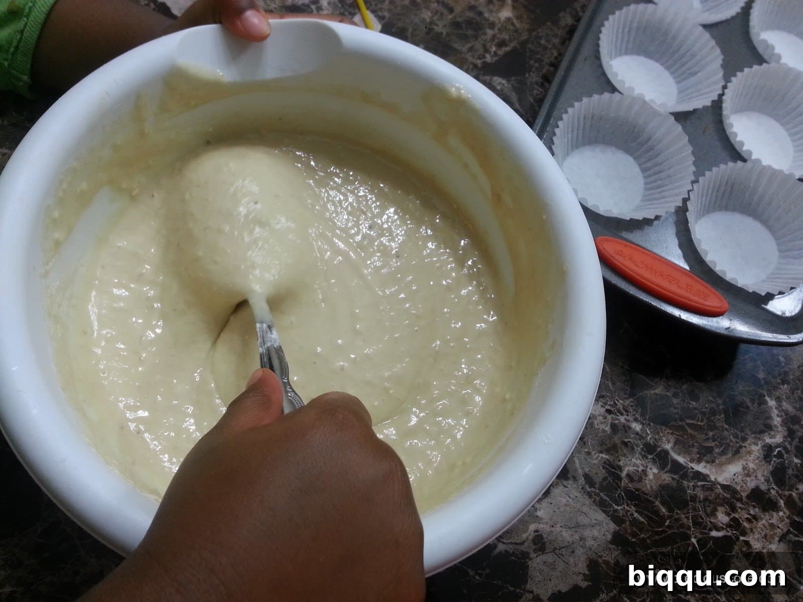 Spoon stirring a bowl of batter.