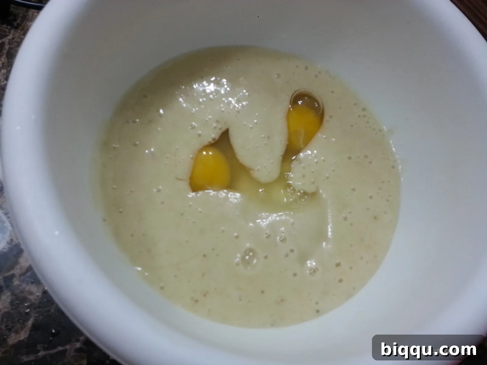 Eggs in a mixing bowl with a banana mixture.