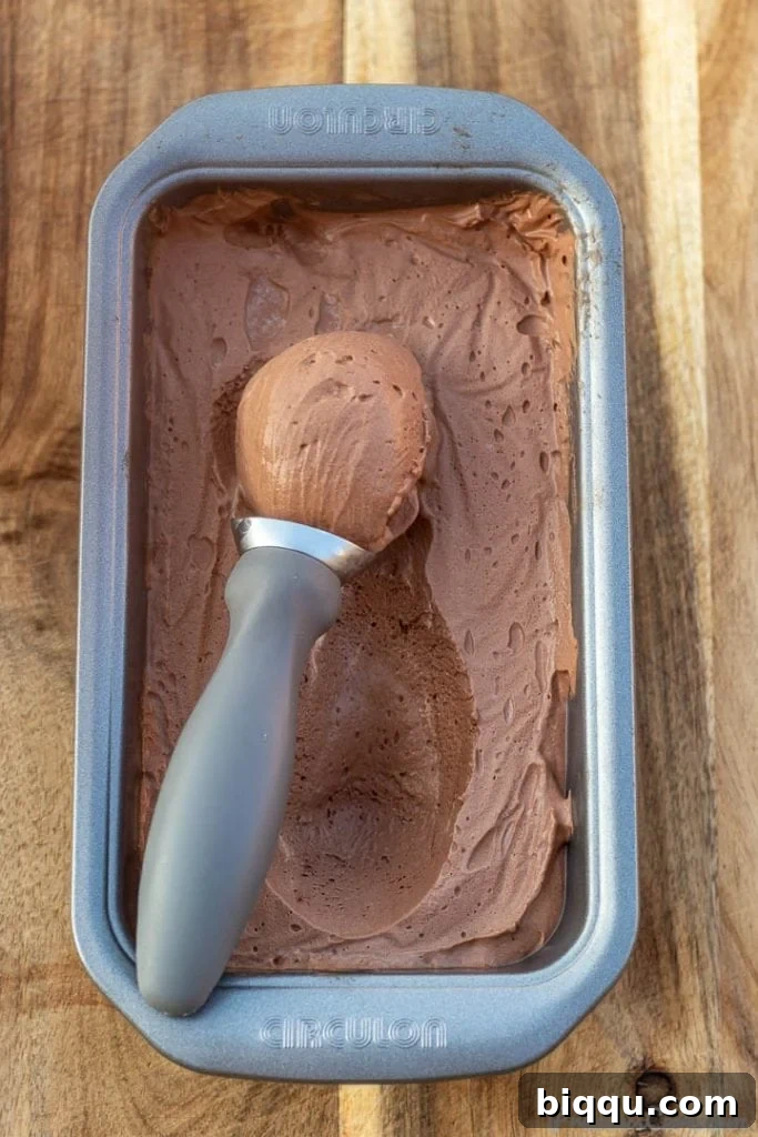 A scoop of creamy chocolate ice cream in a loaf pan, showcasing its perfect texture