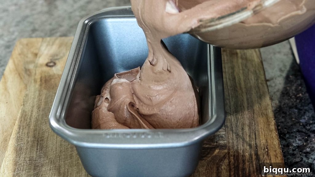 Pouring the chocolate ice cream mixture into a loaf pan for freezing