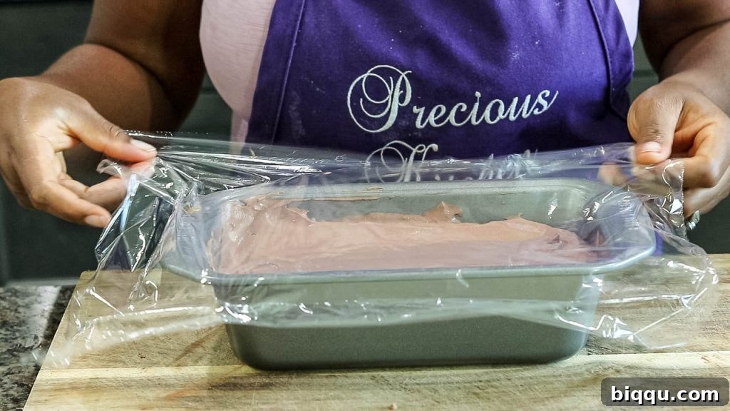 Covering the ice cream mixture tightly with plastic wrap, touching the surface