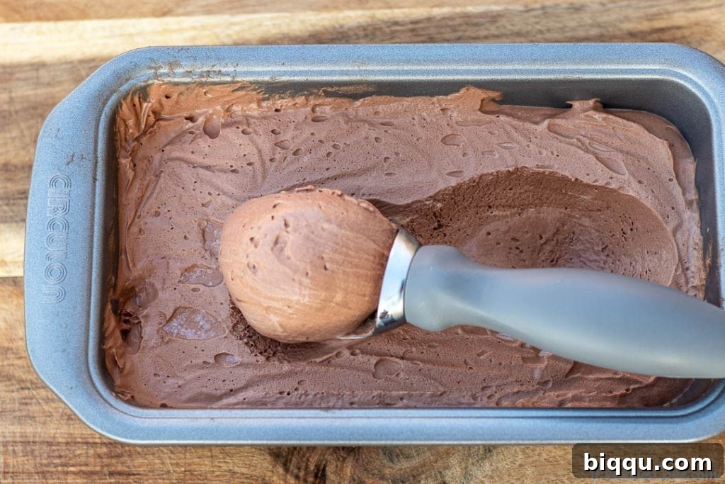 A scoop of perfectly frozen chocolate ice cream in the loaf pan, ready to serve