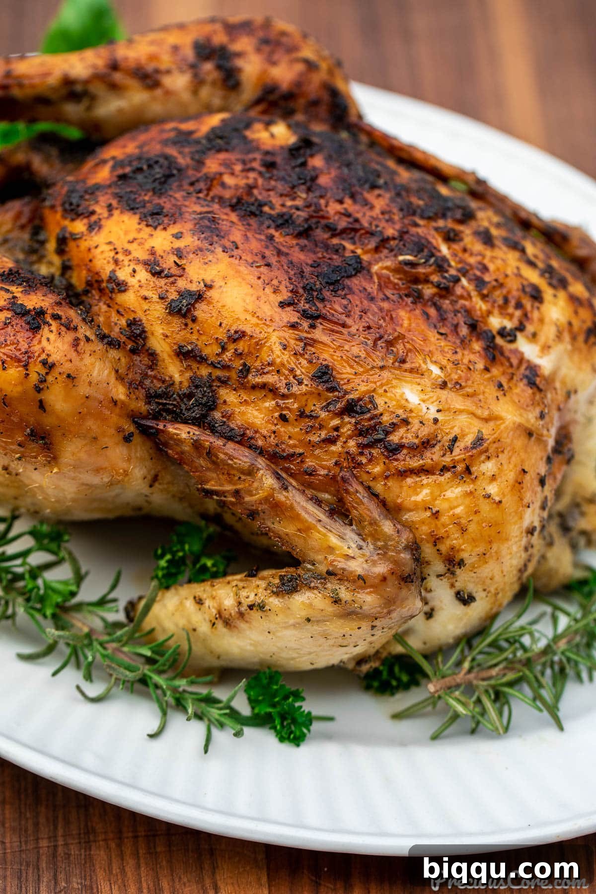 Close-up shot showing one side of golden roasted chicken, highlighting its crispy skin.
