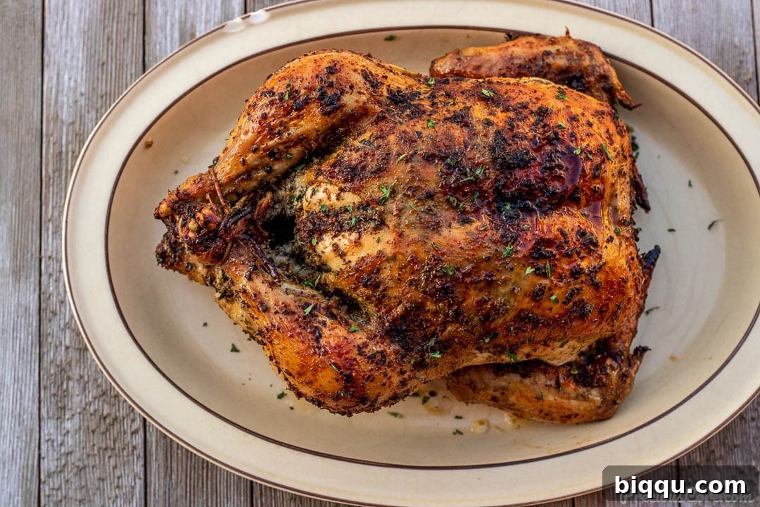 A beautifully roasted whole chicken on a large serving platter, ready to be carved and enjoyed.