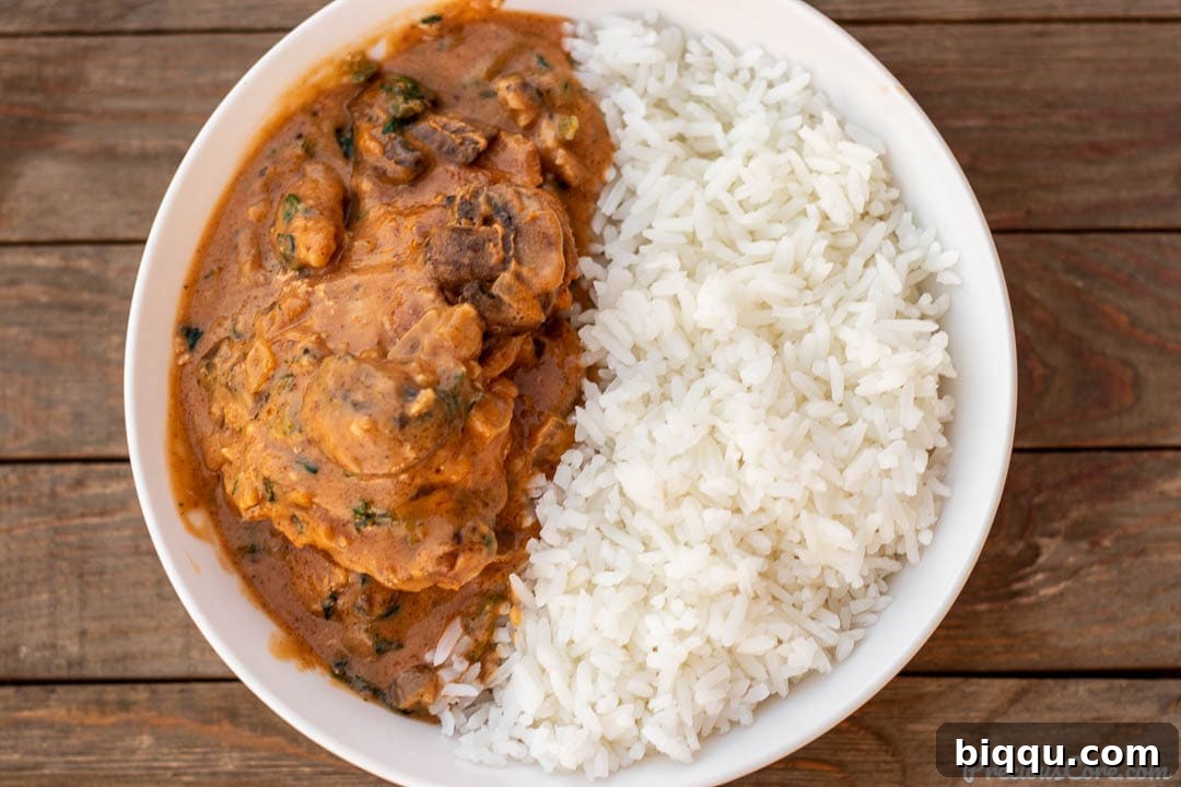 Landscape picture of chicken peanut stew and rice, garnished and ready to eat.