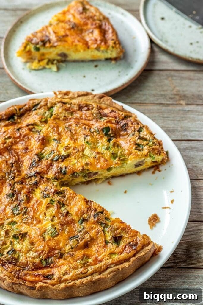 Deliciously Simple Quiche 2 A perfectly baked Easy Quiche on a pristine white plate, showcasing its golden-brown crust and rich filling.