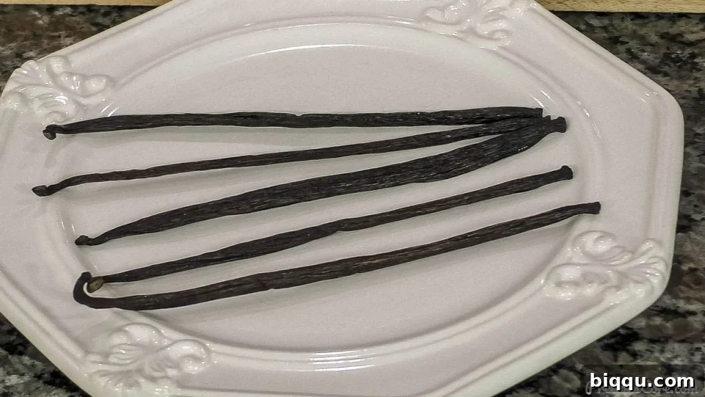 Exotic Tahitian vanilla beans displayed elegantly on a plate