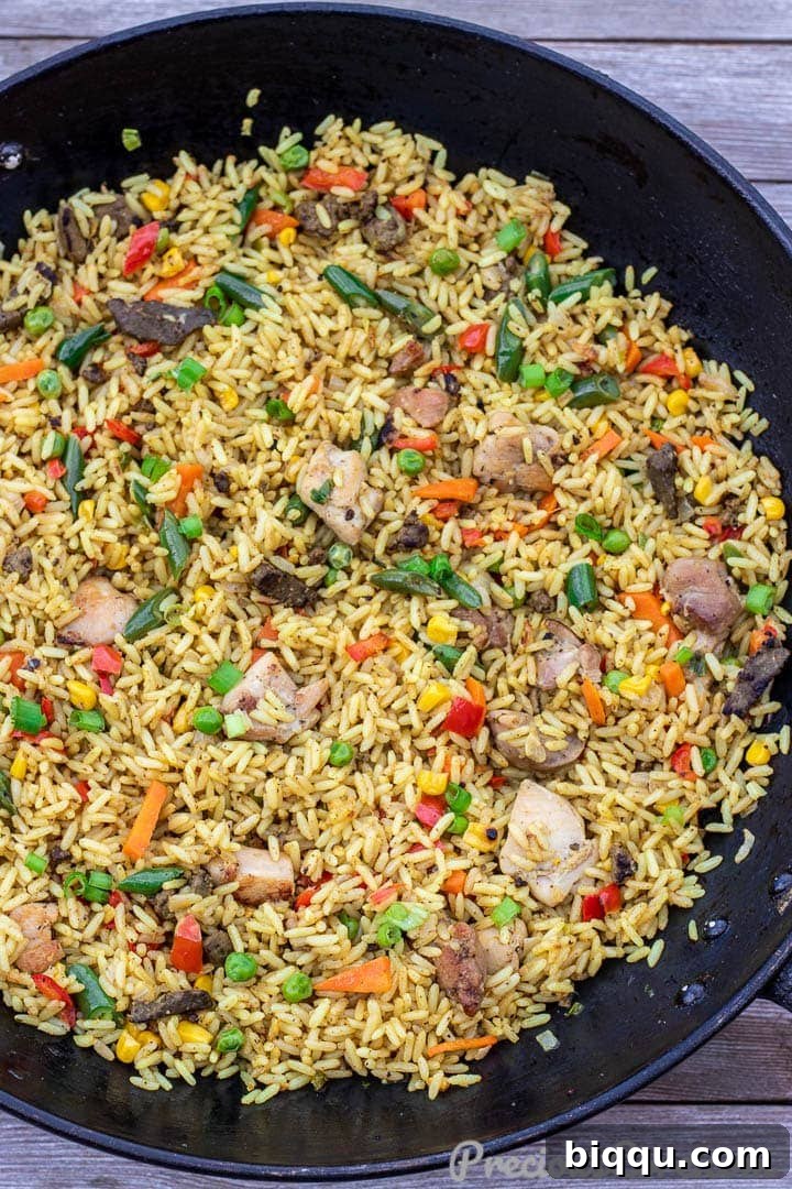 Wok filled with vibrant African Fried Rice, ready to be served