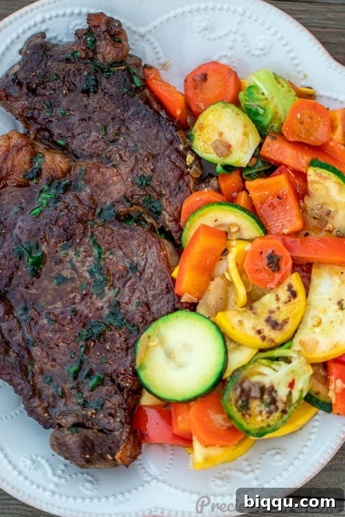Seared Ribeye Perfection 8 A beautifully plated pan-seared steak, sliced against the grain, accompanied by a vibrant medley of sautéed vegetables on a white plate.