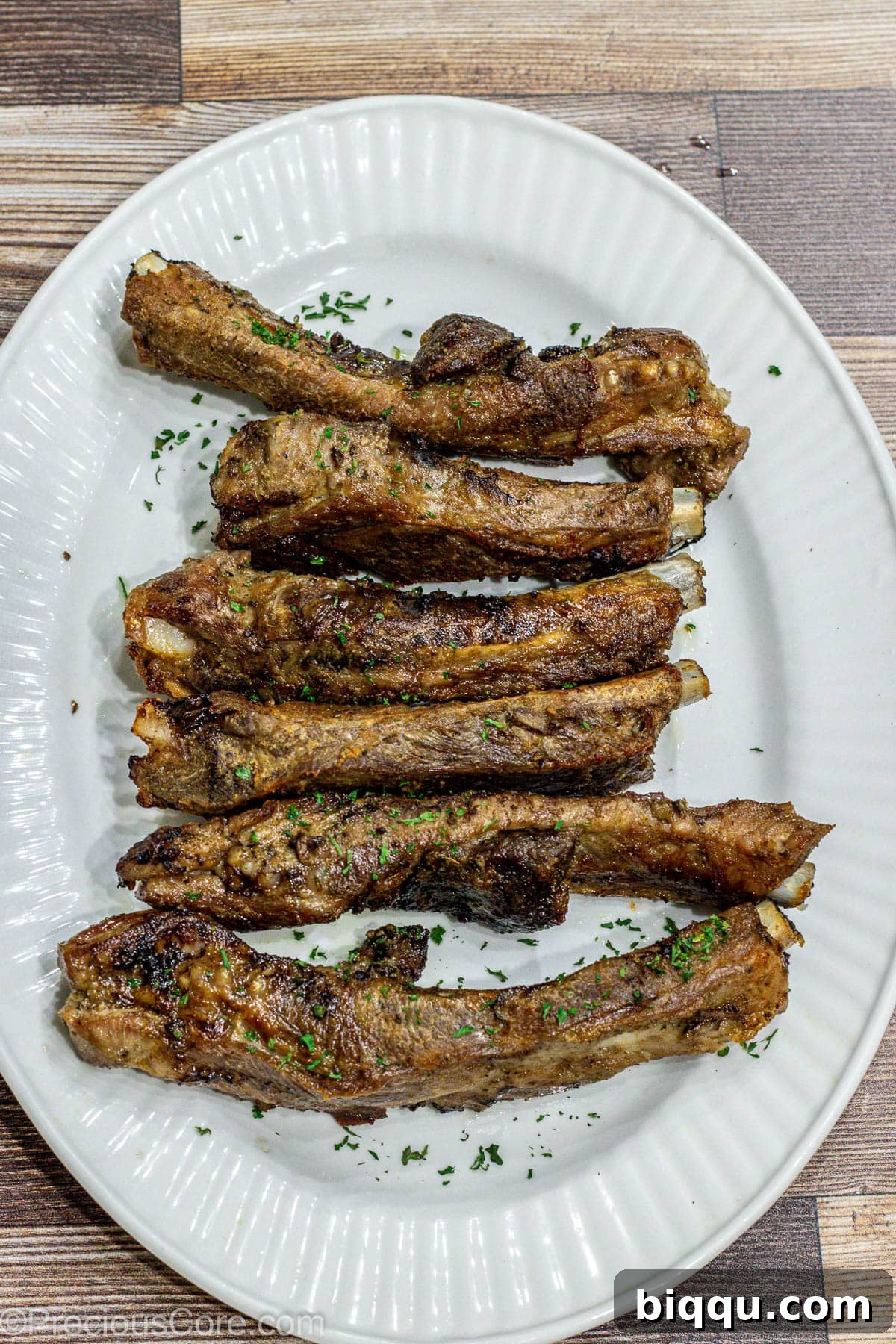 A generous serving of perfectly broiled dry rub ribs presented on an elegant serving tray, ready to be carved and enjoyed.