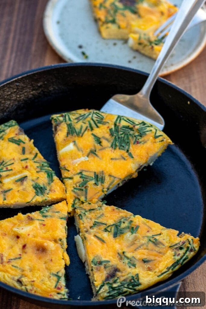 Golden-brown slices of Potato Frittata nestled in a rustic cast iron skillet, ready to be served.