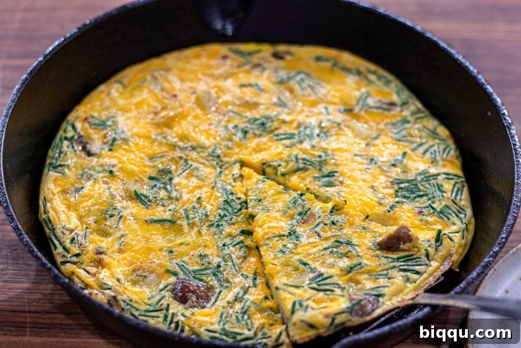 A vibrant Potato Frittata, golden and bubbly, expertly cooked in a classic cast iron skillet, ready to be sliced.