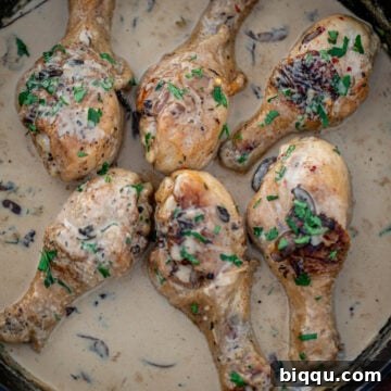 Chicken drumsticks in creamy sauce in a cast iron skillet