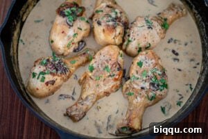 Creamy chicken sauce simmering, showing its rich, thickened consistency in a cast iron skillet.
