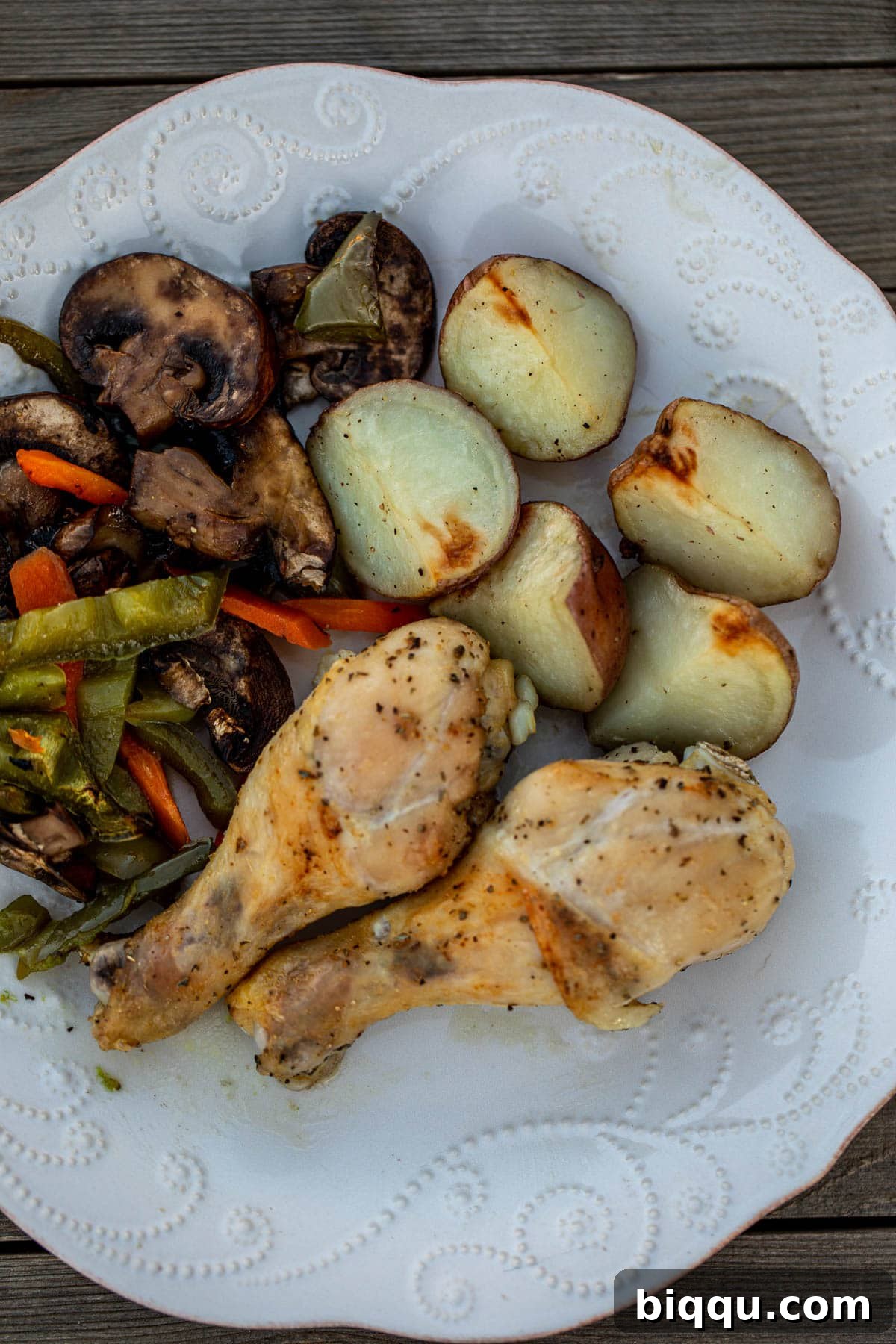 A plate of perfectly roasted chicken, potatoes, and mixed vegetables