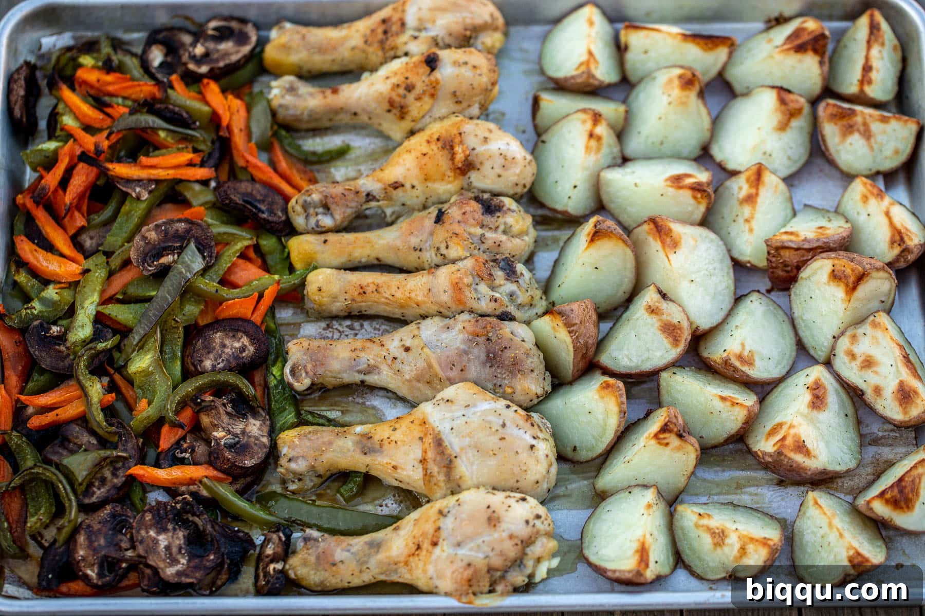 Landscape photo of baked chicken, potatoes, and vegetables fresh out of the oven