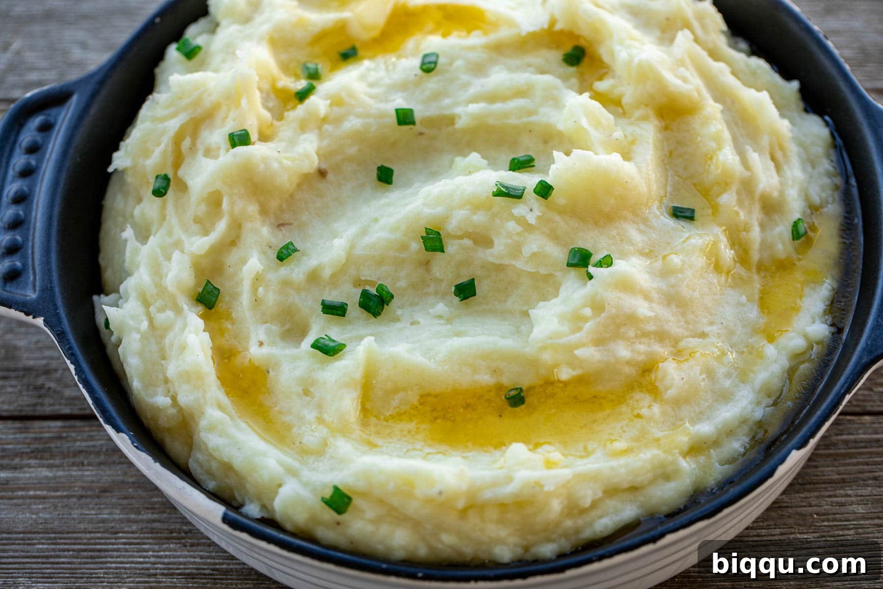 Landscape view of buttermilk mashed potatoes in a serving dish, garnished with fresh chives.