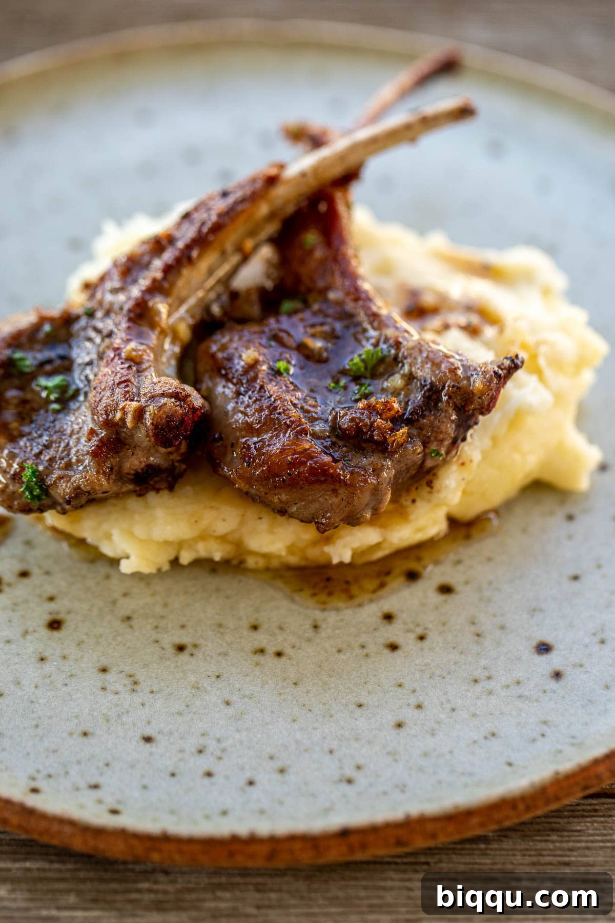 A plate featuring a generous serving of buttermilk mashed potatoes alongside perfectly pan-seared lamb chops.