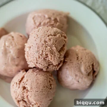 Scoops of no-churn strawberry ice cream on a plate