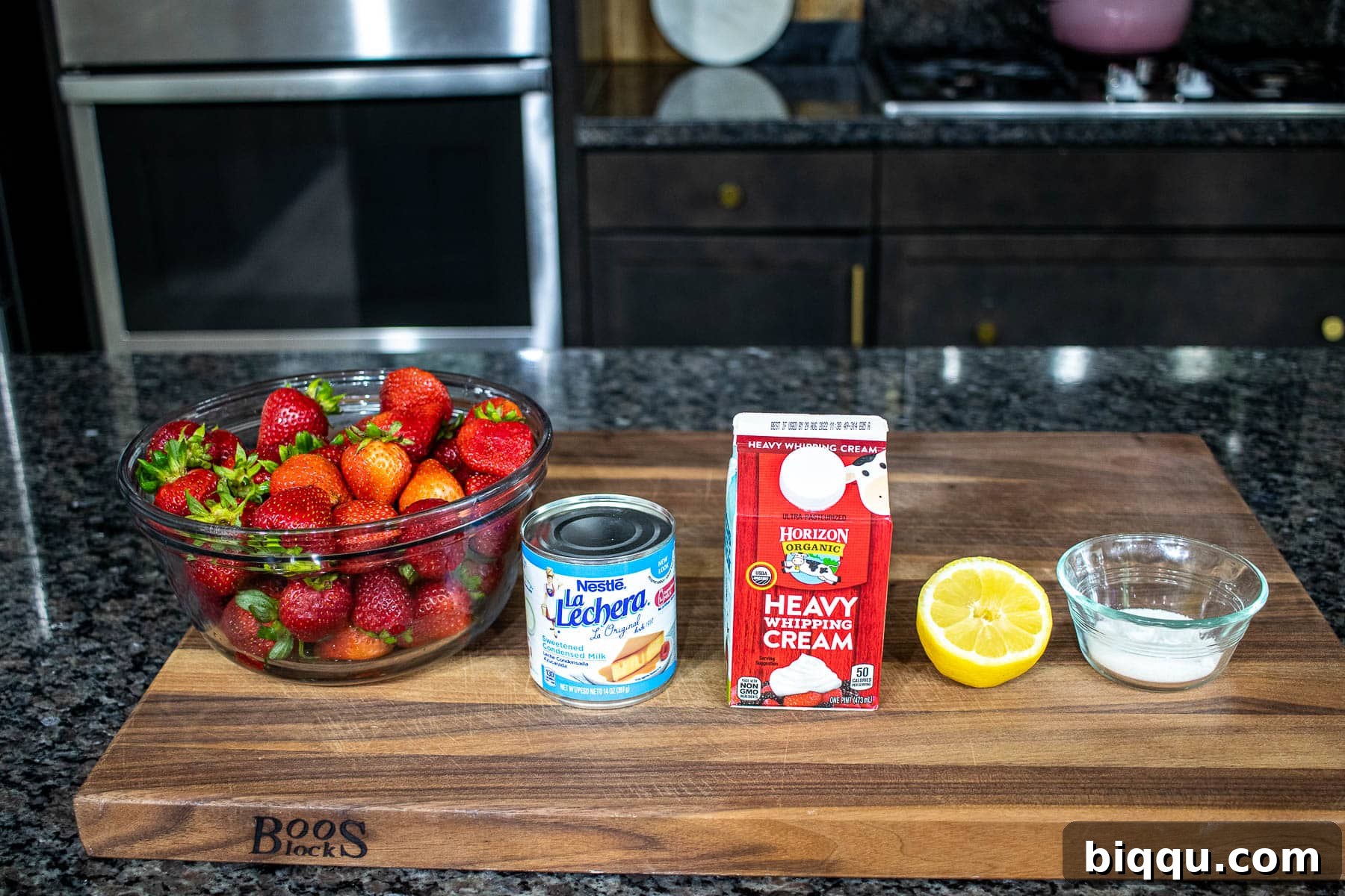 Creamy No-Churn Strawberry Dream 4 Fresh strawberries, sugar, and lemon juice neatly arranged on a chopping board, ready for making homemade ice cream.