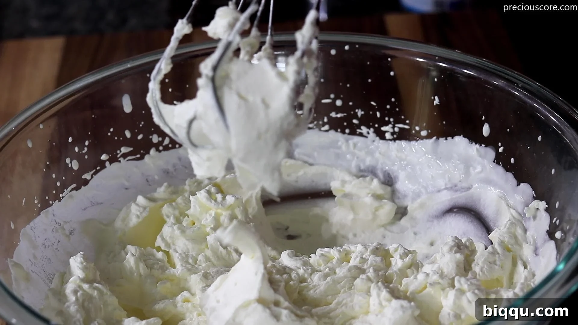 Creamy No-Churn Strawberry Dream 6 Fluffy, perfectly whipped heavy cream in a large mixing bowl, forming stiff peaks.