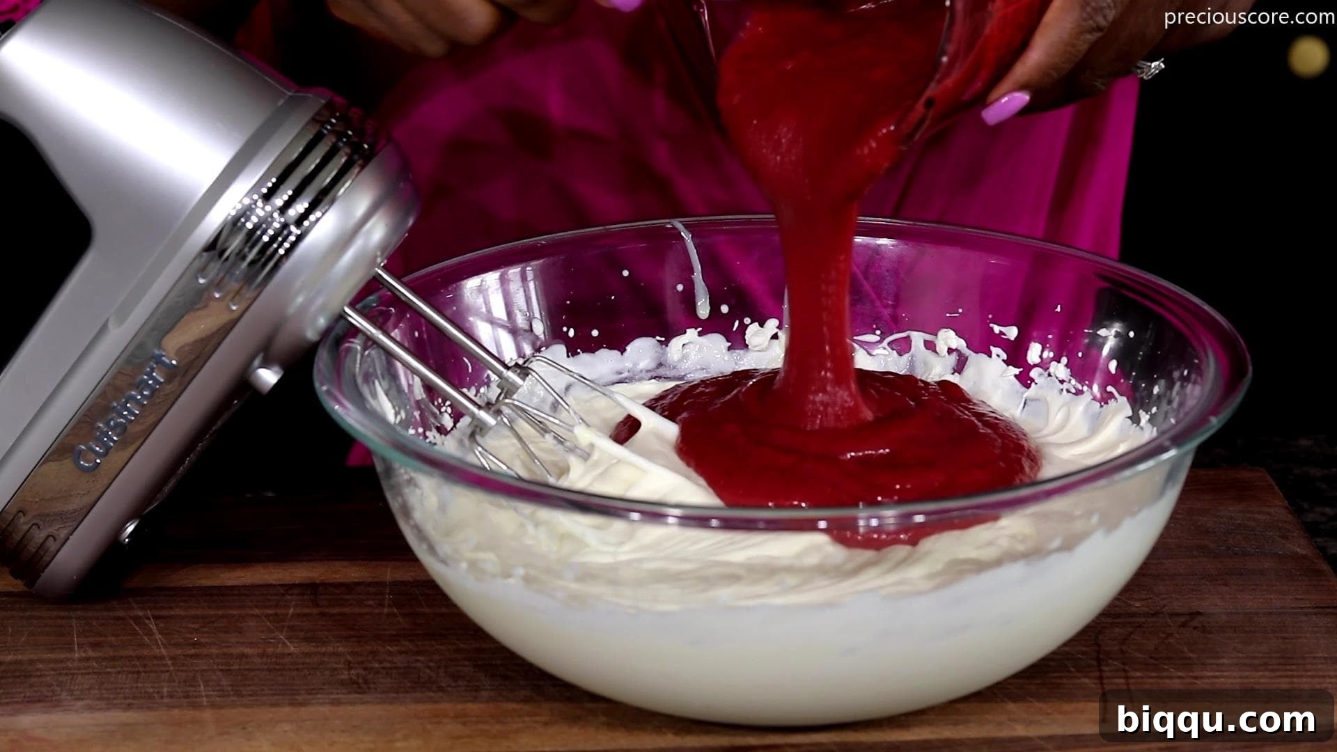 Creamy No-Churn Strawberry Dream 7 The vibrant strawberry puree being gently folded into the cloud-like whipped cream, creating a swirl of colors.
