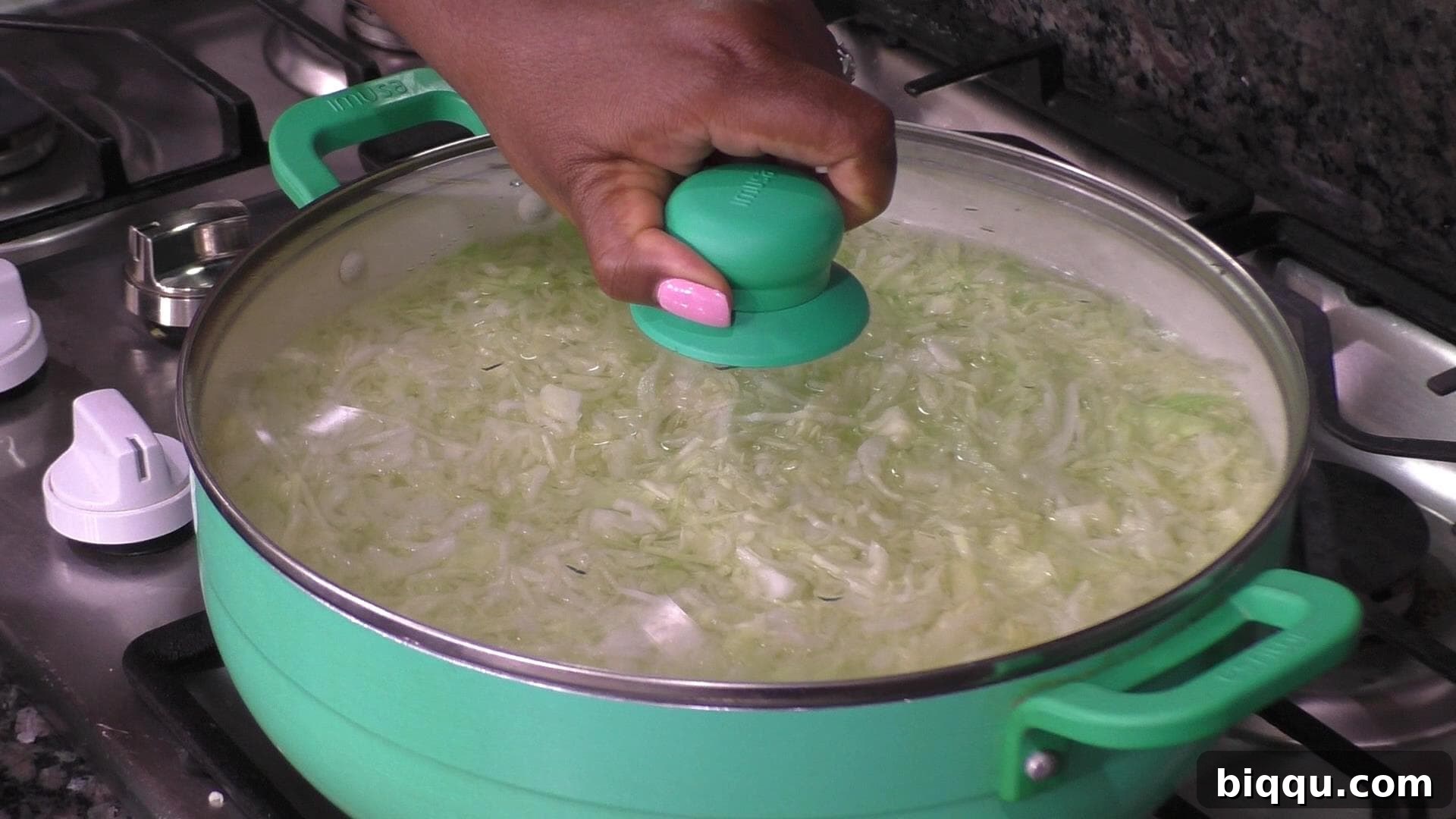 Shredded cabbage gently submerged in a pot of hot water, illustrating the blanching process.