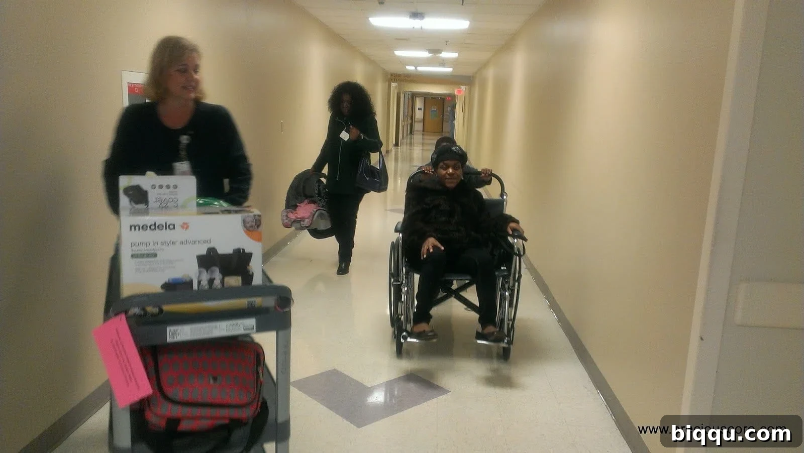 Mother and baby leaving hospital in wheelchair