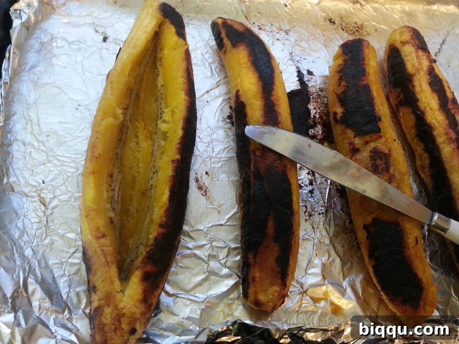 Roasted plantain being cut lengthwise to create a pocket