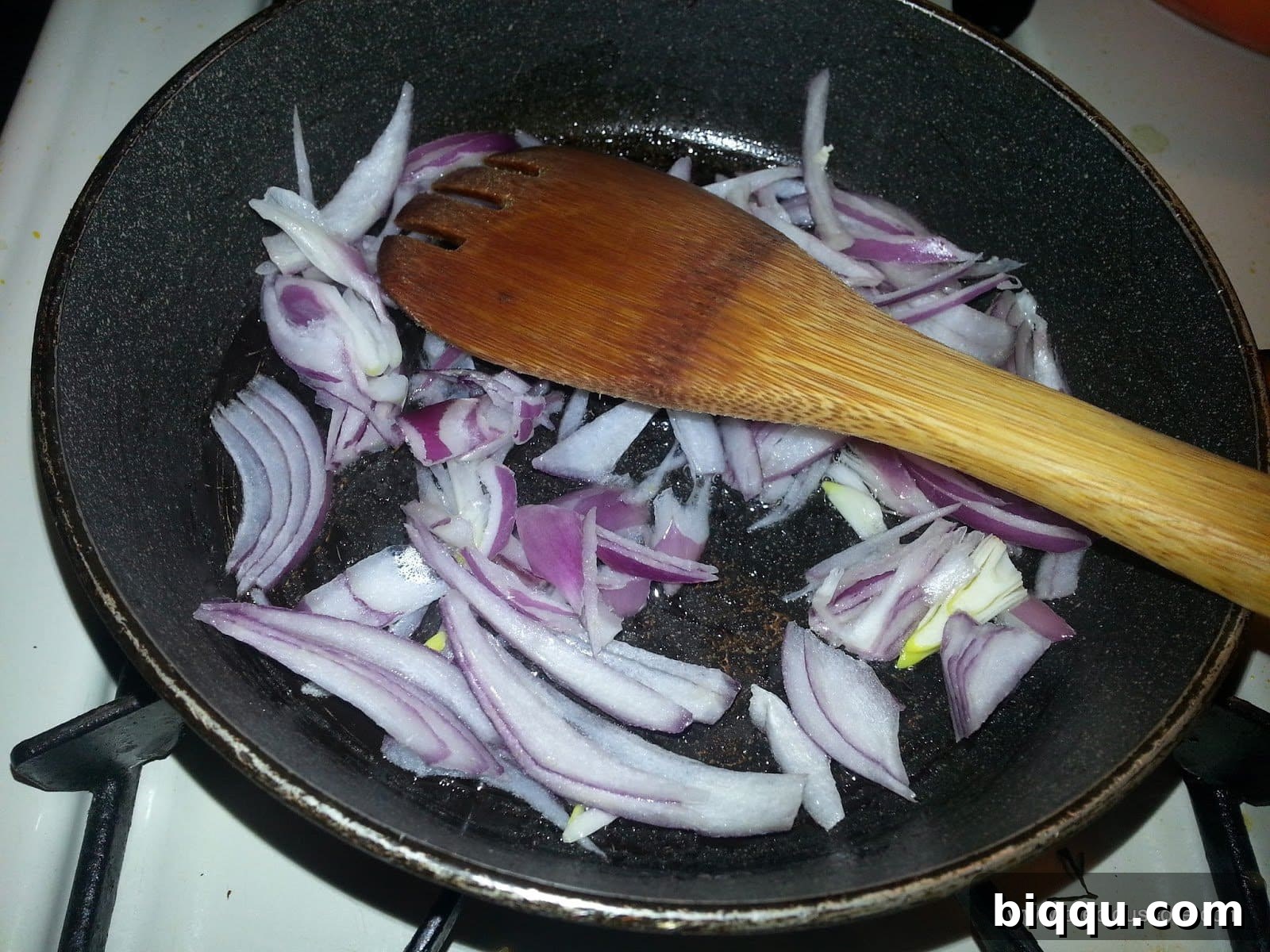 Chopped onions sautéing in a pan with olive oil