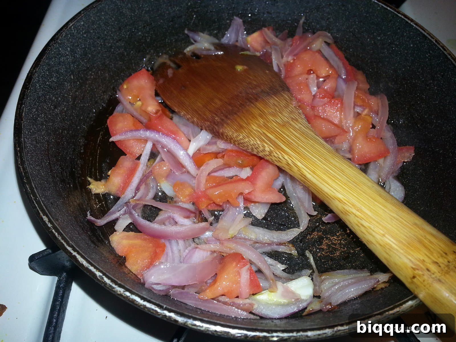 Chopped tomatoes added to the sautéed onions