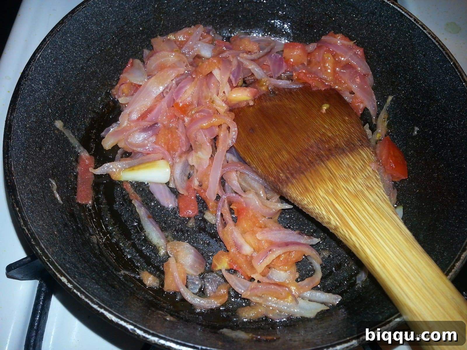 Tomatoes softening and cooking down in the pan