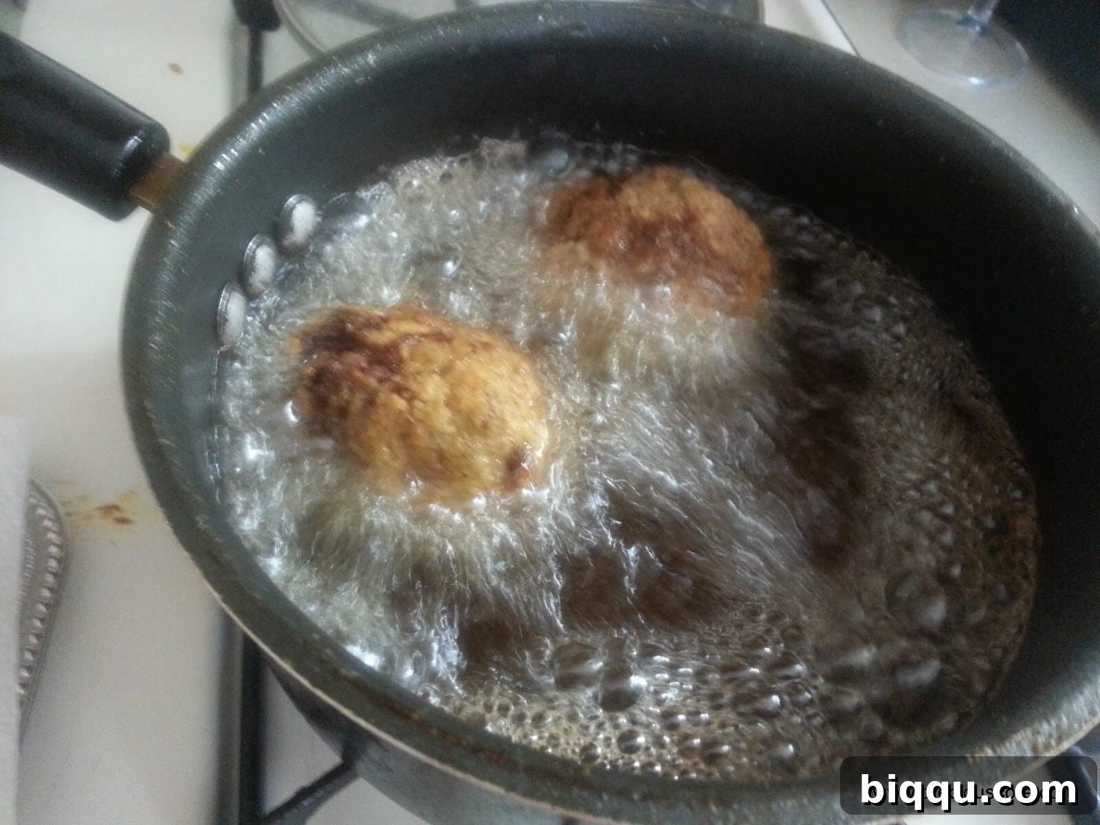 Perfectly golden-brown Scotch Eggs, freshly fried and crispy, cooling on a rack.