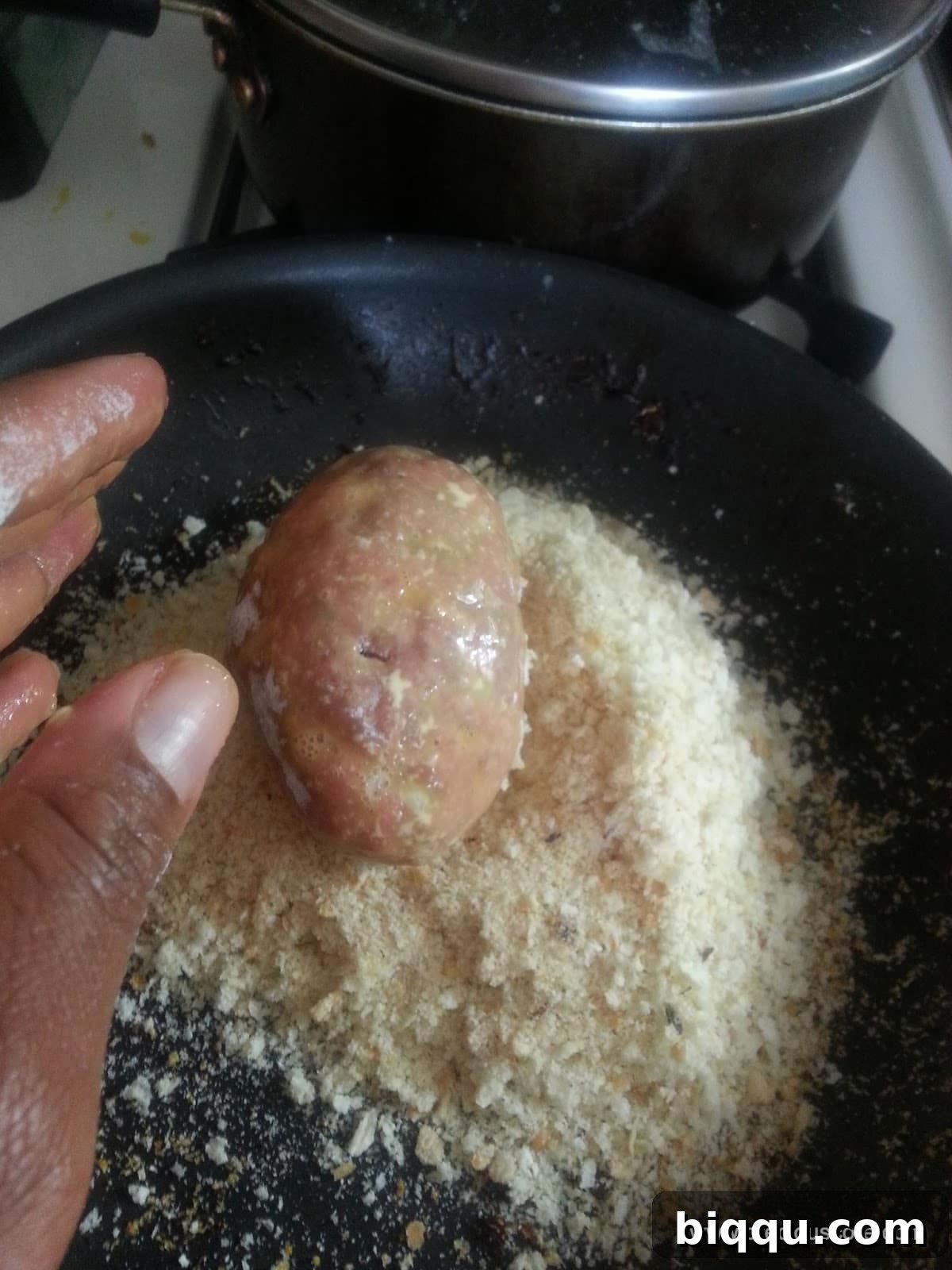 Scotch egg fully coated with crispy breadcrumbs, perfectly prepared and ready for frying.