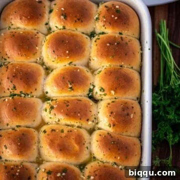 A full baking dish of dinner rolls brushed with garlic butter