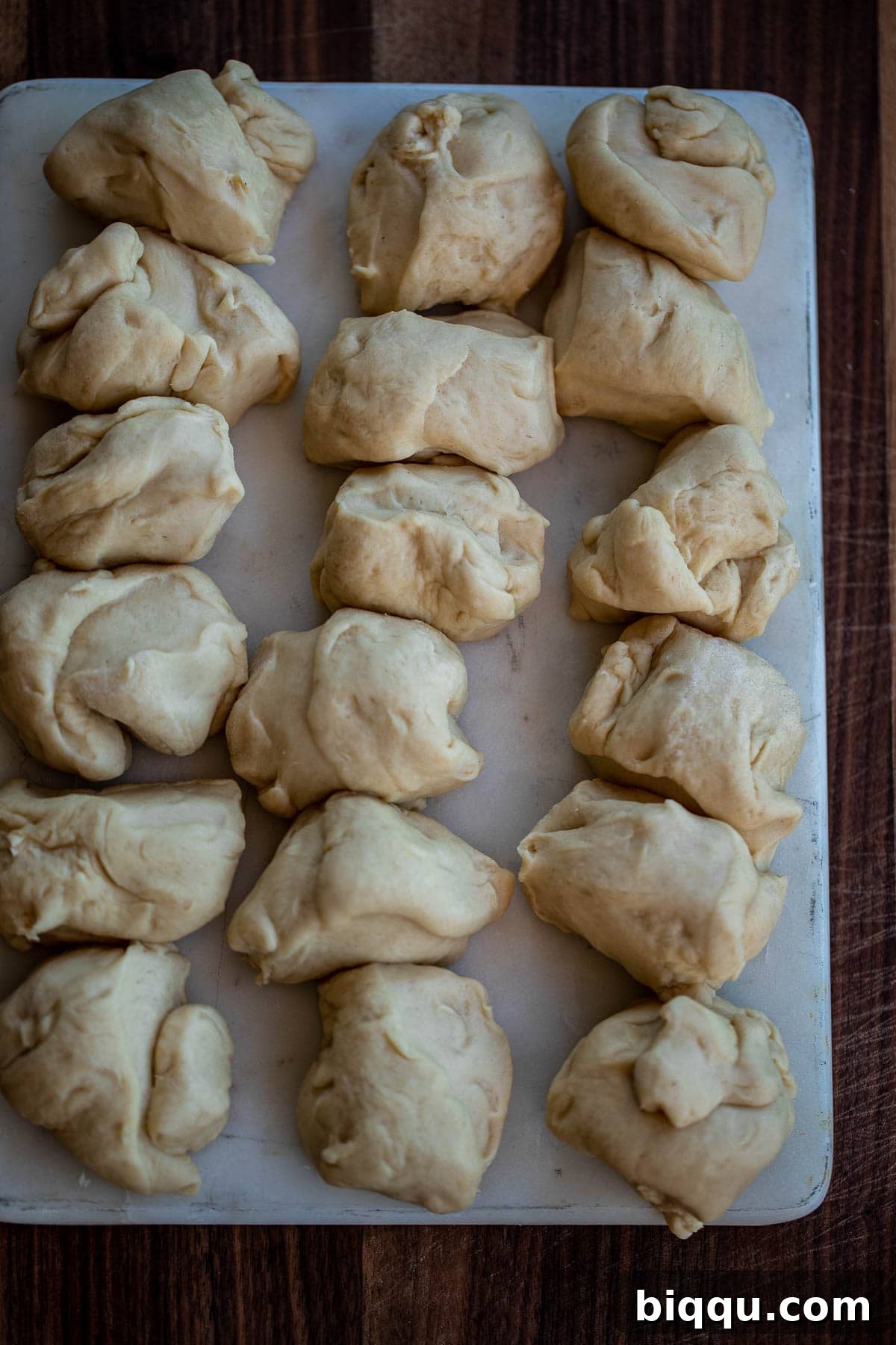 Dough divided into 18 equal pieces on a floured surface.